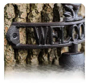 Macro detail of rustic cast iron welcome doorbell with frog sculpture and bell component