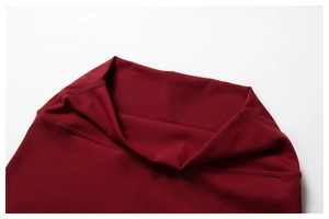 Dettaglio dei pantaloni da yoga a vita alta con cuciture rinforzate in rosso scuro