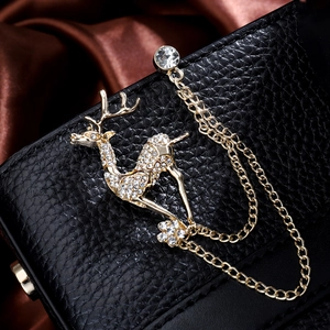 Exquisite deer brooch with sparkling crystals and golden chains on black leather background
