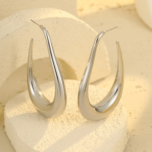 Modern hollow U-shaped stainless steel stud earrings in silver on geometric props