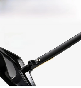 Macro shot of robust metal hinge on glossy black square-frame sunglasses with screws