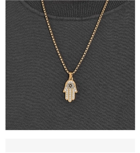 Detail of Hamsa Hand pendant with sparkling crystals on a golden chain necklace