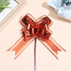 Macro detail of large metallic red bow ribbon with elegant gold trim for gift wrapping