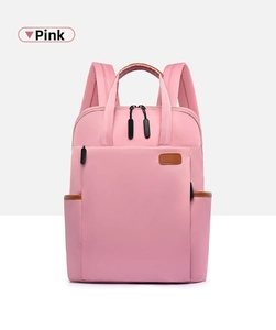Detail of pink backpack featuring brown leather accents and durable zipper compartments
