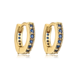 Detailed view of gold hoop earrings with micro-set blue stones and natural reflections
