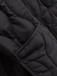 Detailed macro view of black quilted puffer jacket fabric with ripstop grid texture