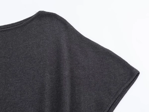 Gros plan détaillé du tissu tricoté gris foncé montrant la texture et les coutures