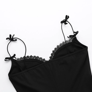 Détail de robe noire avec décolleté en V en dentelle et bretelles à nœud délicates