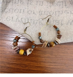 Detailed macro view of Bohemian beaded hoop earrings with shell tassels and wooden beads
