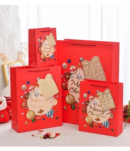 Detail of red Merry Christmas gift bags in various sizes with golden lettering and tags