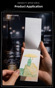 Close-up of a vintage-style paper bookmark with street lamp illustration and lace edge