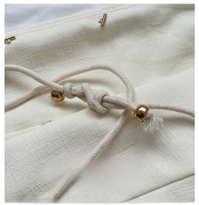 Détails du sac seau tissé avec cordons en coton et perles sphériques dorées