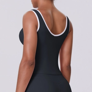 Détail du passepoil contrasté blanc sur le débardeur de yoga noir avec dos en U ouvert
