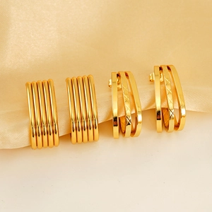 Minimalist irregular multi-layer gold earrings with fine textured patterns on satin