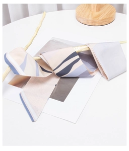 Abstract geometric silk scarf draped on a wooden branch with soft morandi tones