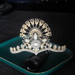 Detail of luxury gold crown with white pearls and rhinestones on a dark surface