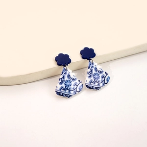 Detail of blue and white porcelain style earrings with floral studs on white steps