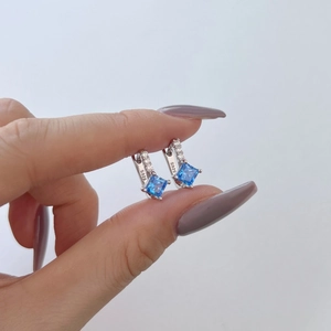 Macro shot of S925 sterling silver earring with blue square gemstone and small side diamonds