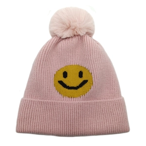 Details der rosa Strickmütze mit gelbem Smiley-Gesicht und flauschigem Bommel-Design