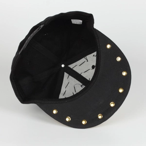 Detail view of adjustable snapback closure and gold rivets on black hip hop cap