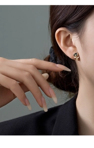 Detail view of retro black rose stud earring with gold stem and sparkling zircon accent