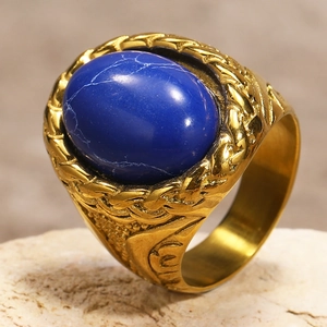 Macro shot of gold woven texture and vintage carvings on a men's blue gemstone ring