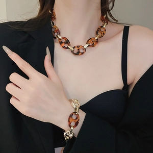 Dettaglio del set collana e bracciale in acrilico tartarugato con chiusura in metallo oro