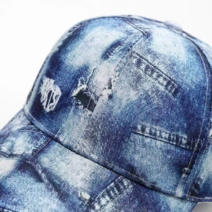 Detail of distressed denim baseball cap showing vintage torn fabric and washed texture