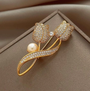 Vue détaillée d'une broche tulipe avec cristaux étincelants et une perle dorée polie