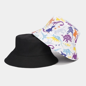 Détail d'un chapeau bob réversible avec motif de dinosaure coloré et côté noir uni