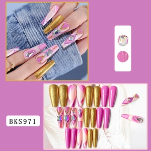 Macro detail of long coffin press-on nails with pink glitter and rhinestone accents