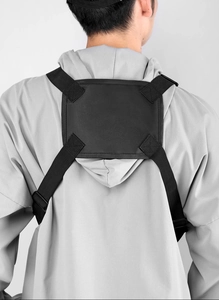 Rear view of tactical vest bag with adjustable nylon straps on model wearing grey hoodie
