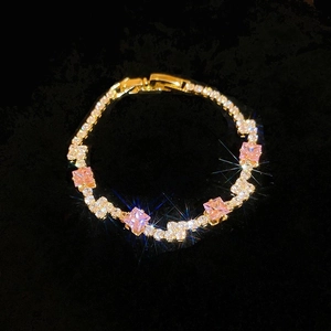 Macro detail of gold-plated butterfly bracelet with pink gemstone and white zirconias