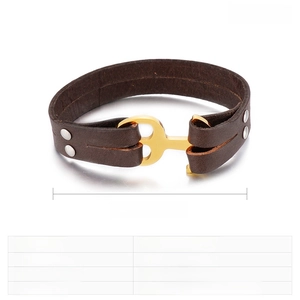 Detail of dark brown braided leather bracelet with golden stainless steel anchor clasp