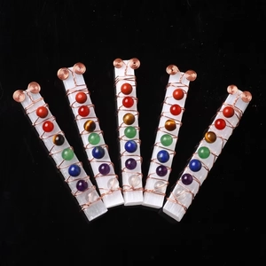 Macro detail of five selenit crystal wands wrapped with copper wire and seven chakra stones