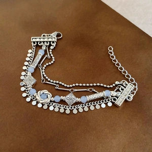 Detailed macro view of vintage multi-layer silver bracelets with light blue beads