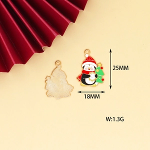 Detail of penguin Christmas charm with enamel finish and gold metal back size 25mm