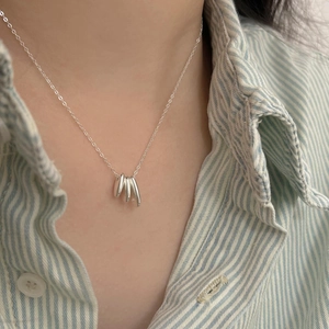 Close-up of minimalist 925 sterling silver oval necklace worn with a striped shirt