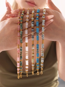Detail of stacked natural stone bead bracelets with gold accents and lobster clasps