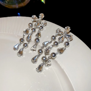 Detail macro shot of cascading silver fringe earrings with crystal waterdrop pendants