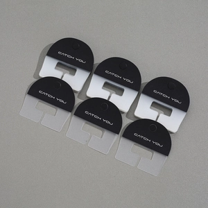 Macro view of six semi-transparent matte phone tether tabs with Catch You text