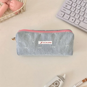Detailed shot of denim fabric stationery pouch with bow embroidery and pink zipper closure