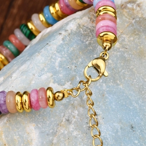 Colorful natural stone beaded bracelet with gold spacers and lobster clasp on stone base