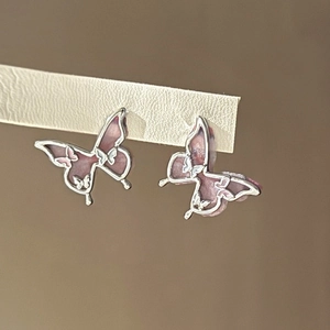 Vue macro de boucles d'oreilles papillon avec ailes en résine rose dégradé et argent