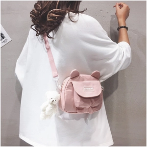 Detail of pink bear canvas crossbody bag with animal ears shown on model back