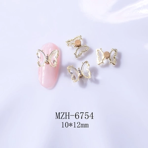 Macro detail of 10x12mm rotating butterfly nail charms with crystals and gold metal edges