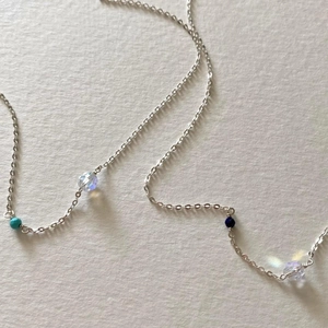 Close-up of a 925 sterling silver chain featuring turquoise and cubic zirconia beads