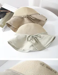 Detail of straw sun hat featuring delicate lace trim and a stylish bow knot tie