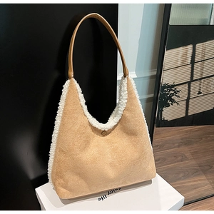 Detail of beige fleece hobo bag with white faux fur trim and brown leather strap
