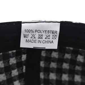 Detail of the 100% polyester wash label inside the plaid baseball cap showing care icons